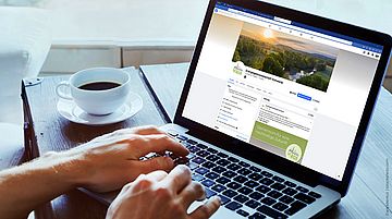 Auf dem Foto sieht man einen aufgeklappten Laptop. Darauf zu sehen ist die neue Facebook-Seite der EnergieGenossenschaft Schwerte eG